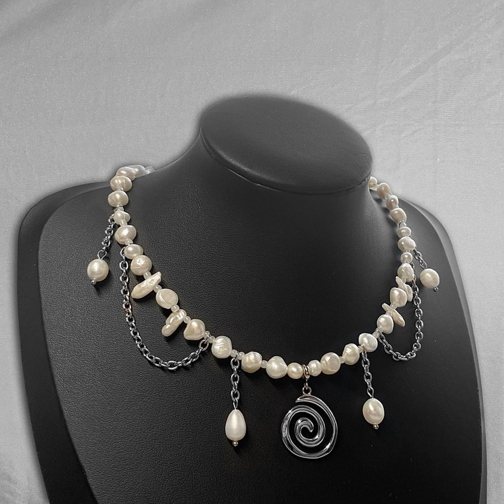 uneven pearl necklace with a stainless steel spiral charm in the middle and hanging chains (14/6)